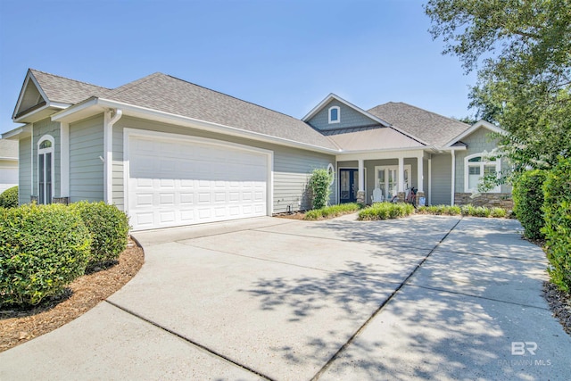 view of front of property featuring an attached garage, driveway, and roof with shingles