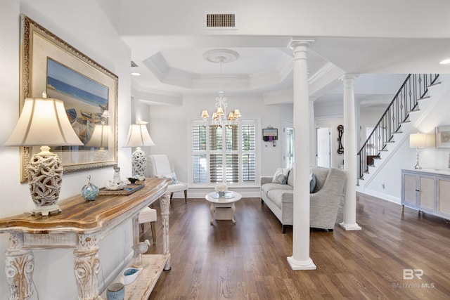 living area with dark wood-style flooring, crown molding, visible vents, a raised ceiling, and decorative columns