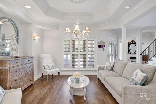 living area featuring dark wood-style flooring, a raised ceiling, and stairs