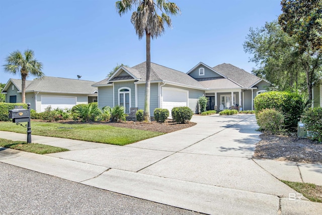 view of front of property with roof with shingles, concrete driveway, a garage, and a front lawn