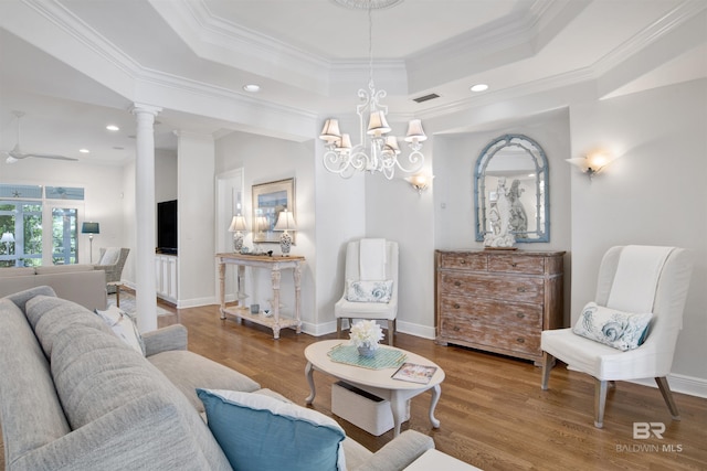 living room featuring crown molding, a tray ceiling, baseboards, and wood finished floors