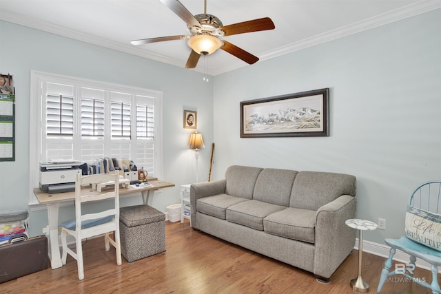 living area featuring baseboards, ornamental molding, a ceiling fan, and wood finished floors