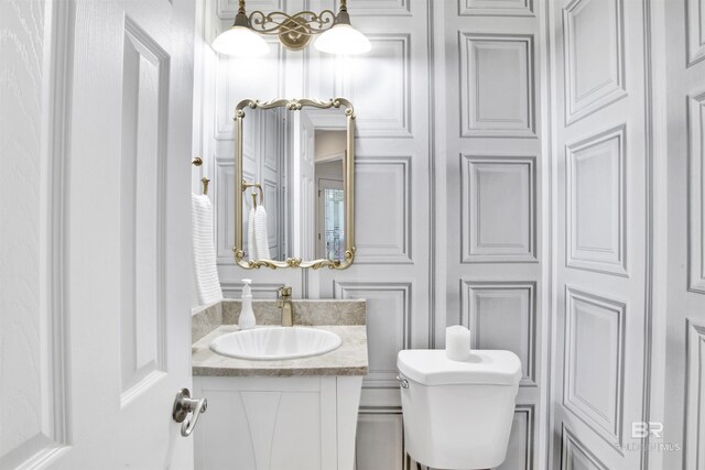 half bathroom featuring toilet and vanity