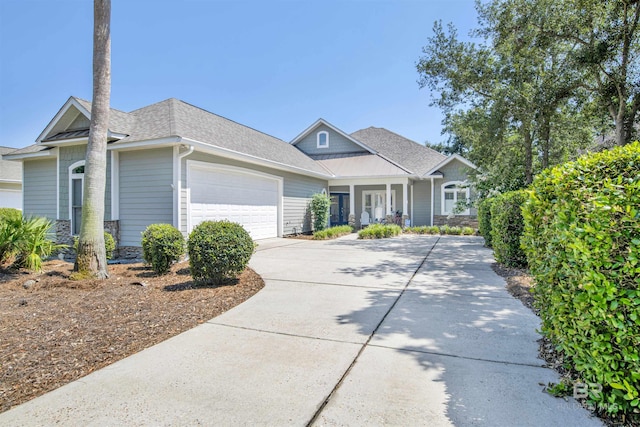 view of front of house with a porch, roof with shingles, driveway, and an attached garage
