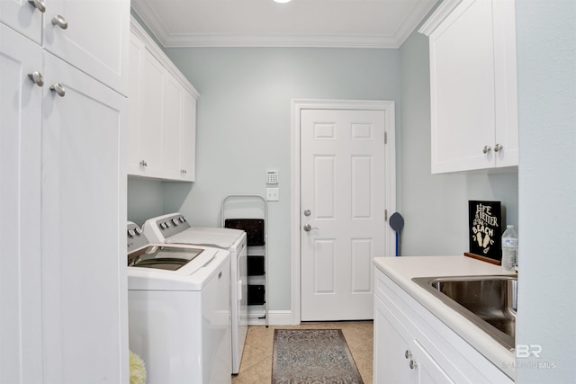 laundry room with crown molding, light tile patterned flooring, washer and clothes dryer, cabinet space, and a sink
