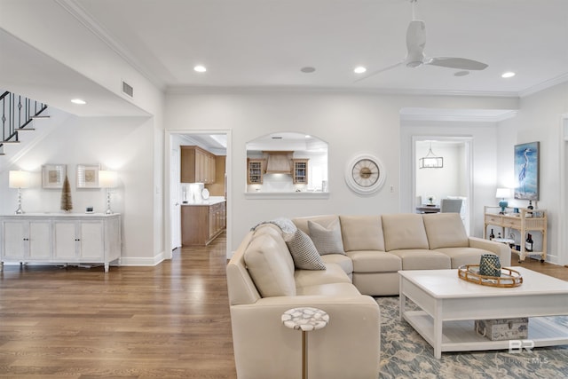 living room with crown molding, wood finished floors, visible vents, and recessed lighting