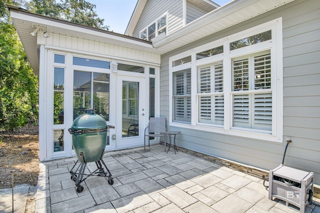 view of patio featuring a sunroom and a grill