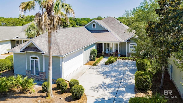 view of front facade with concrete driveway, a shingled roof, stone siding, and an attached garage