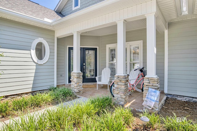 doorway to property with a shingled roof and covered porch