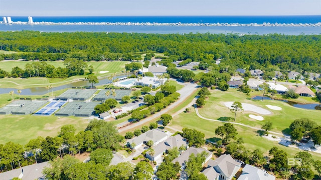 aerial view with golf course view, a forest view, and a water view