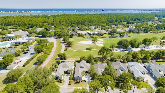 drone / aerial view featuring a water view, golf course view, a residential view, and a view of trees