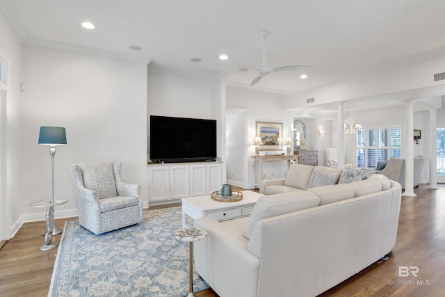 living area featuring light wood-style flooring, ornate columns, a ceiling fan, and ornamental molding