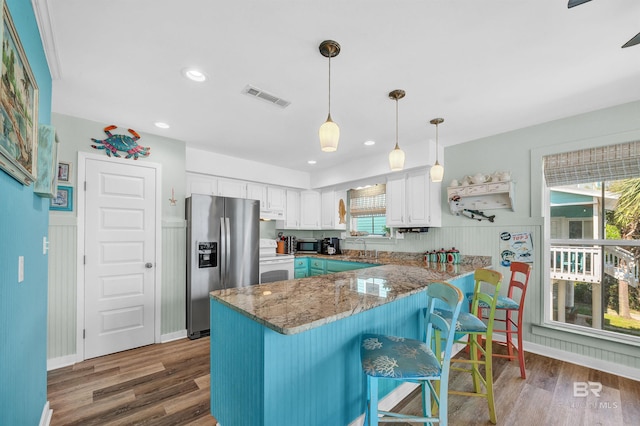 14752 State Highway 180, Gulf Shores, AL 36542 - kitchen featuring stainless steel appliances, a peninsula, white cabinets, wood finished floors, and stone countertops
