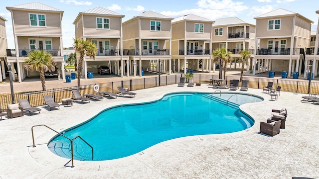 pool featuring a patio, a residential view, and fence