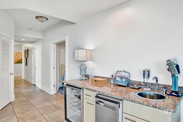 kitchen featuring light stone countertops, sink, dishwasher, beverage cooler, and light tile patterned floors