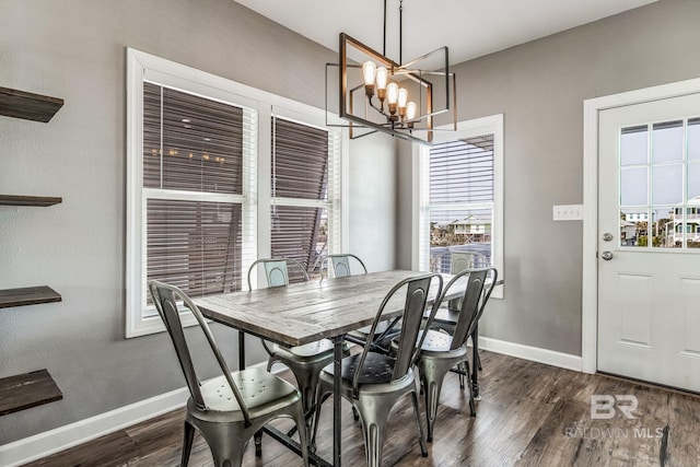 dining area featuring dark wood-type flooring and a notable chandelier