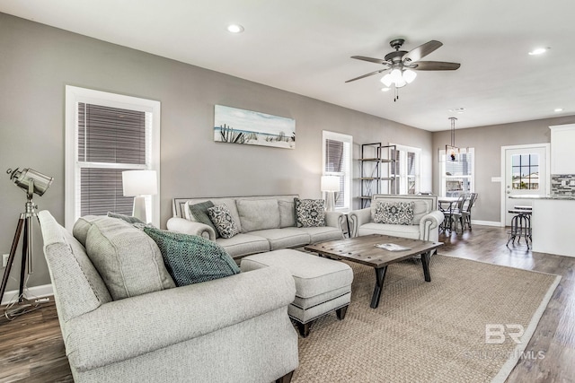 living room with ceiling fan and dark hardwood / wood-style flooring