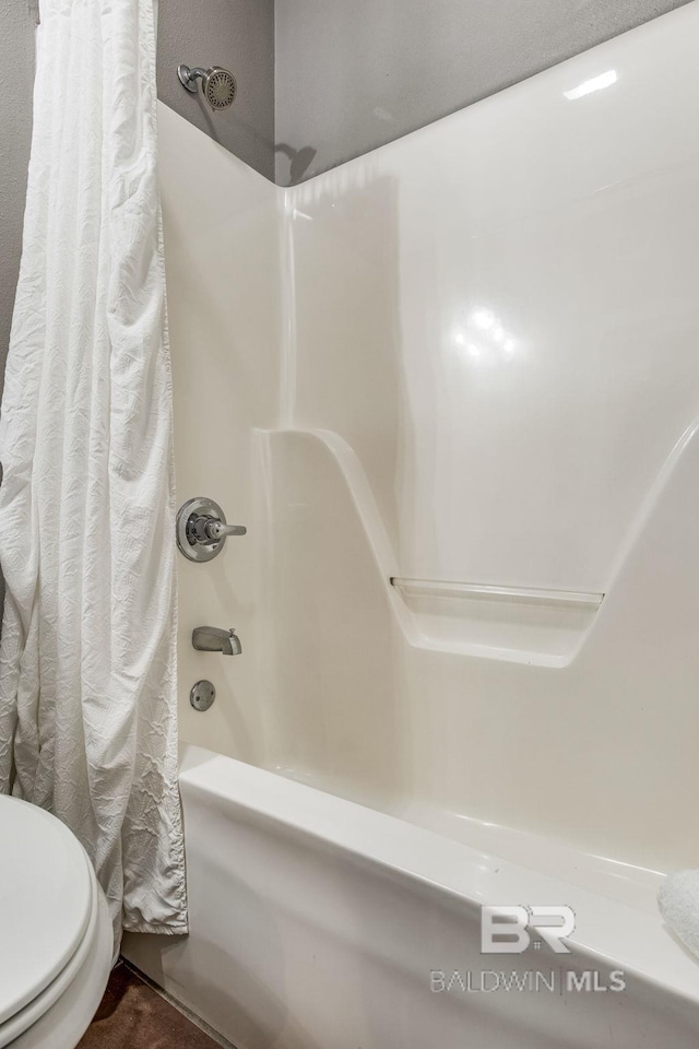 bathroom with shower / tub combo with curtain and toilet