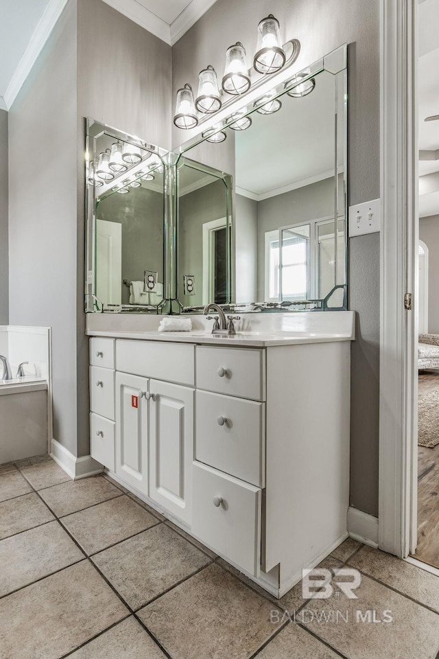 bathroom with ornamental molding, a bathing tub, tile patterned flooring, and vanity