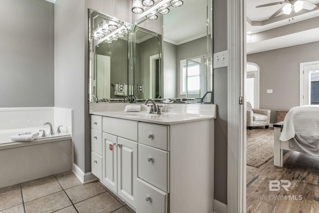 bathroom featuring crown molding, ceiling fan, a bathtub, vanity, and tile patterned floors