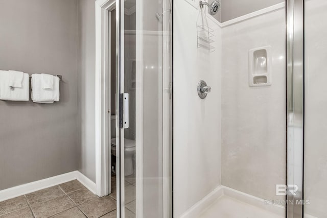 bathroom featuring a shower, tile patterned floors, and toilet