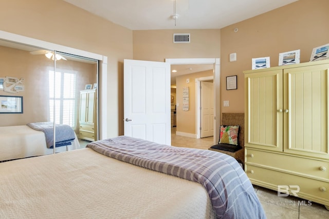 bedroom featuring a ceiling fan, visible vents, and light tile patterned floors