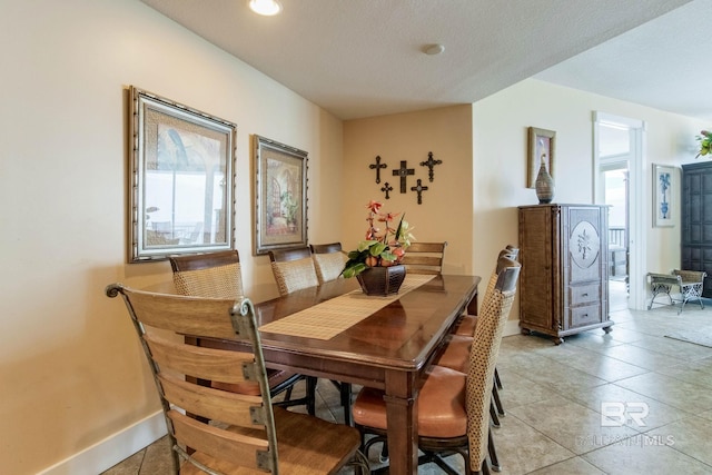 dining space featuring light tile patterned floors and baseboards