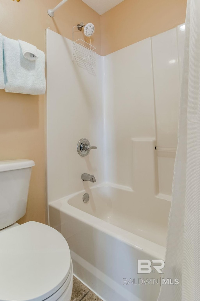 bathroom featuring shower / tub combo and toilet