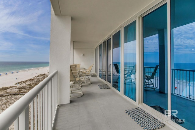 balcony featuring a water view and a view of the beach