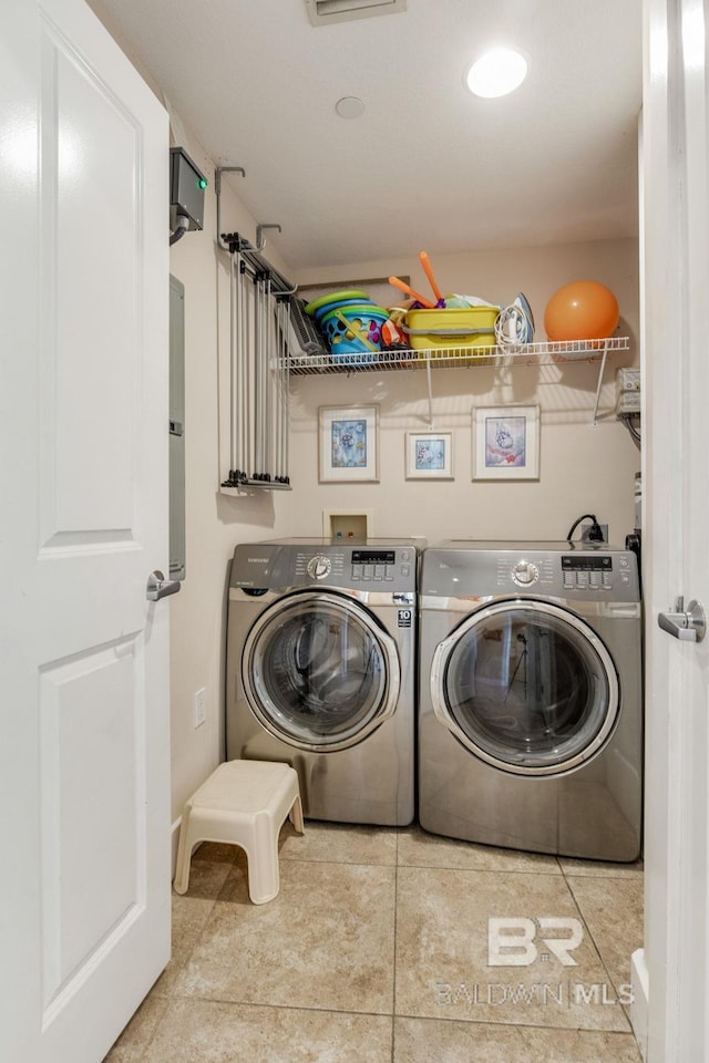 clothes washing area with laundry area, washer and clothes dryer, and tile patterned floors