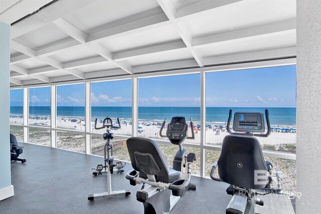 workout area featuring expansive windows, coffered ceiling, and a water view