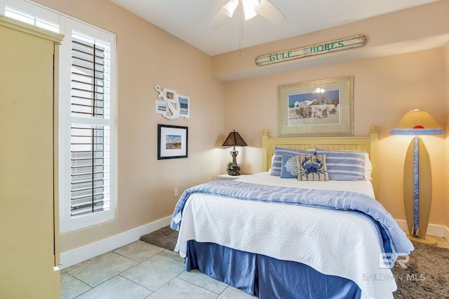 bedroom with a ceiling fan, baseboards, and tile patterned floors