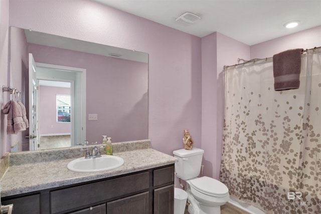 bathroom featuring vanity, toilet, and curtained shower