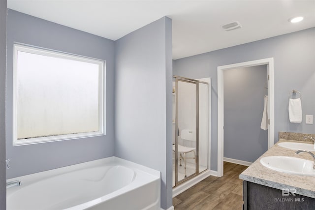 bathroom featuring independent shower and bath, vanity, and hardwood / wood-style flooring