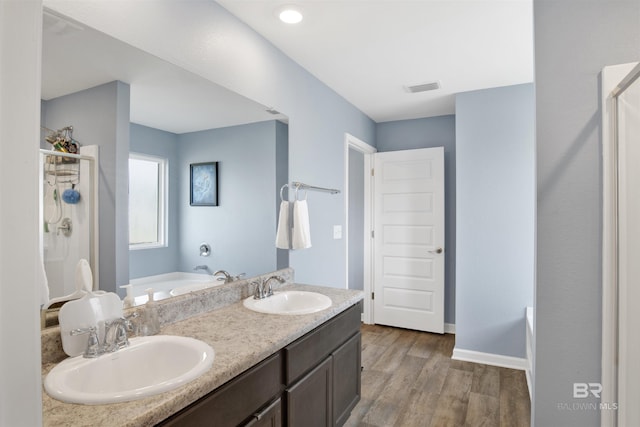 bathroom with vanity, hardwood / wood-style flooring, and independent shower and bath