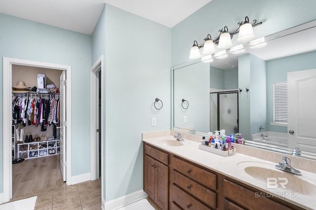 full bathroom featuring a garden tub, double vanity, a stall shower, and a sink