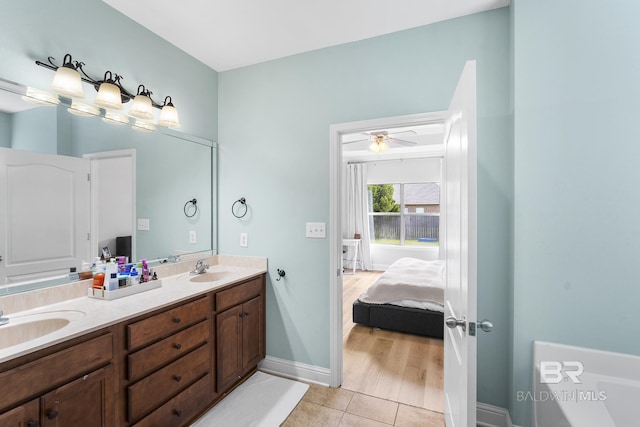 bathroom with tile patterned flooring, double vanity, ensuite bathroom, and a sink