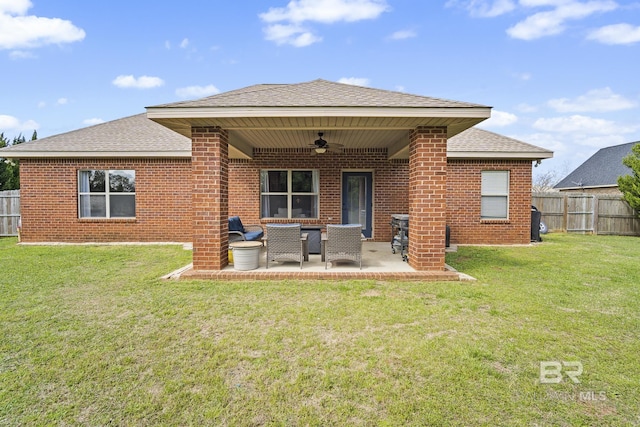 rear view of house featuring fence, brick siding, and ceiling fan