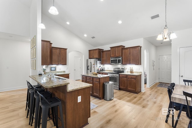 kitchen featuring arched walkways, visible vents, appliances with stainless steel finishes, and a sink