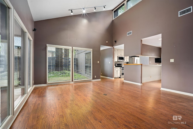 6 Pirates Ln, Spanish Fort, AL 36527 - unfurnished living room featuring rail lighting, light wood-style flooring, and a high ceiling