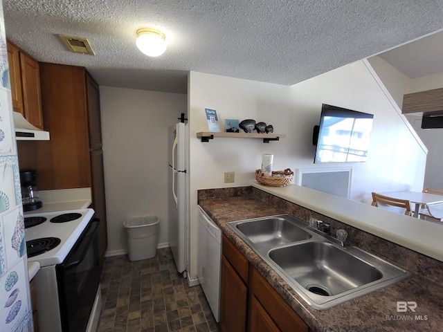 kitchen with white appliances, a textured ceiling, and sink