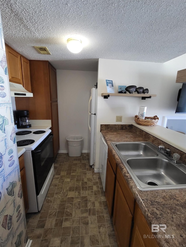 kitchen with sink, a textured ceiling, and white appliances