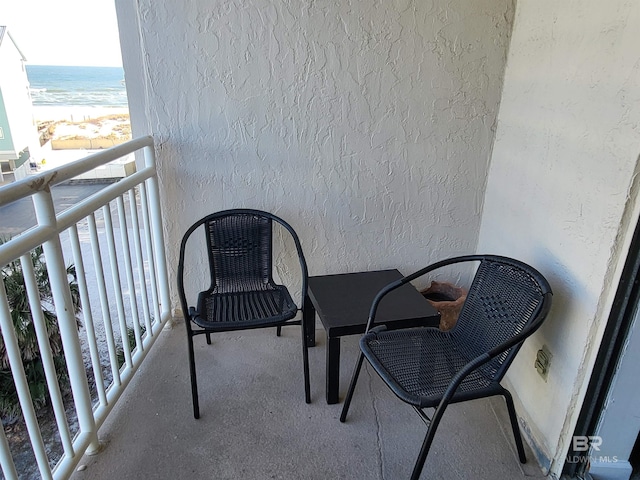 balcony featuring a water view and a view of the beach