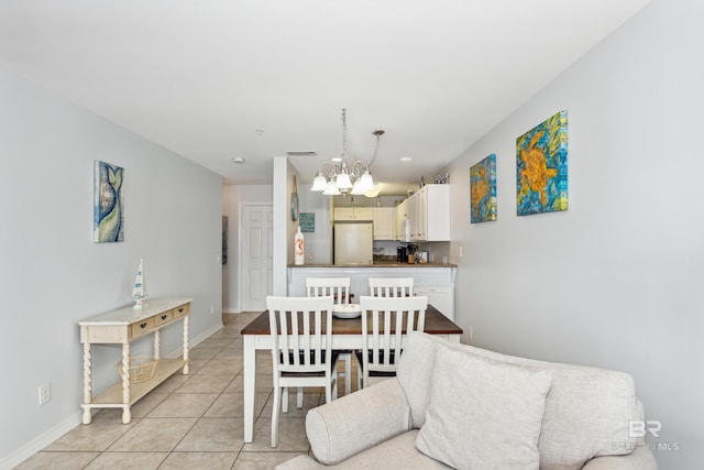 tiled dining room with an inviting chandelier