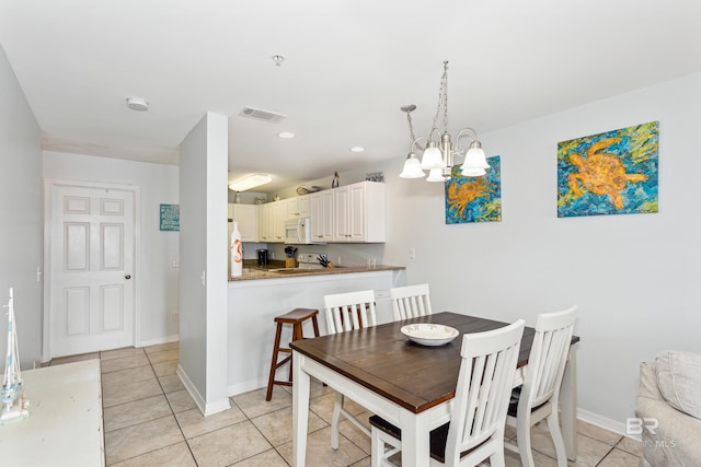 dining space featuring a notable chandelier and light tile patterned flooring