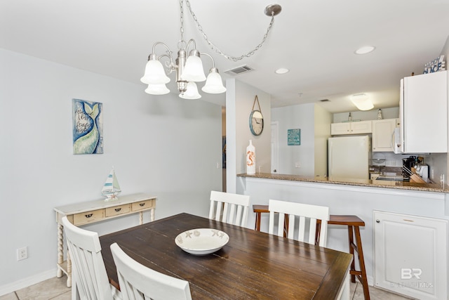 dining space with an inviting chandelier and light tile patterned flooring