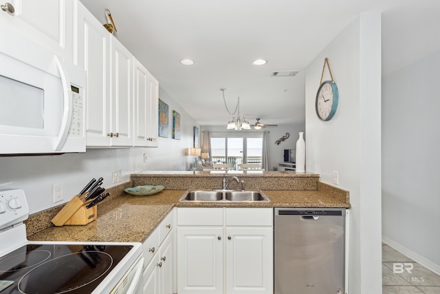 kitchen featuring an inviting chandelier, white appliances, light tile patterned floors, sink, and white cabinets