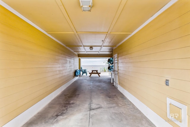 interior space featuring wooden walls and concrete flooring