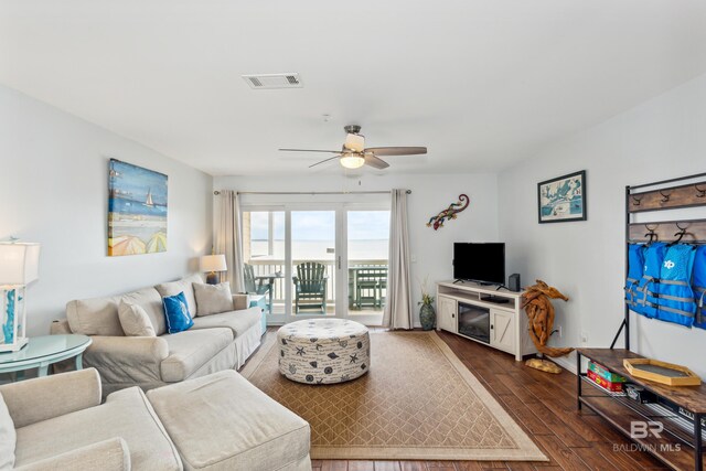 living room with dark wood-type flooring and ceiling fan