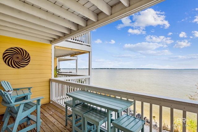 balcony with a water view and a view of the beach